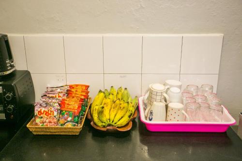 a counter with two baskets of food and bananas and drinks at Barn1920s Hostel in Vientiane