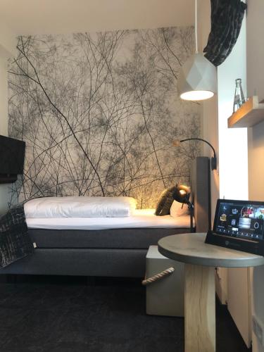 a bedroom with a bed and a table and a laptop at Boutique Hotel K7 in Bad Nauheim