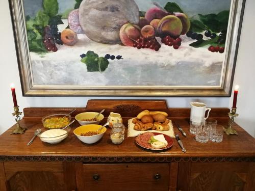 a table with food on it with a painting at Bakovenbay Luxury Suites in Cape Town