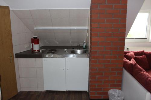 a small kitchen with a sink and a brick wall at Pension Dräger in Mühl Rosin