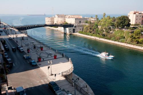 a boat traveling down a river in a city at Hotel Europa in Taranto