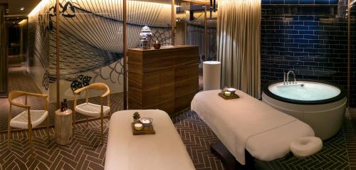 a bathroom with a tub and a sink and a bath tub at Hotel Yehuda in Jerusalem