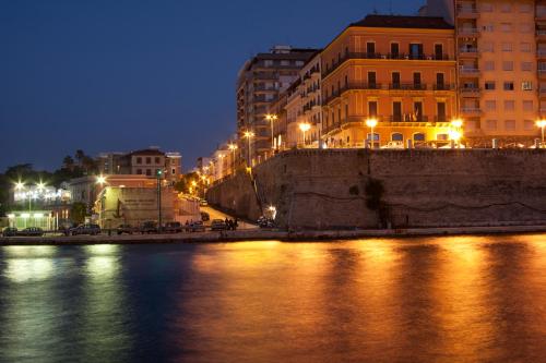 a city at night with lights on the water at Hotel Europa in Taranto