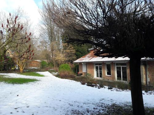 a house with snow on the ground in front of it at Un grand jardin en ville. Chez Guy in Brussels