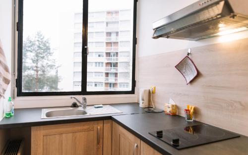 リモージュにあるAppartement cosy entièrement rénovéのキッチン(シンク付)、窓