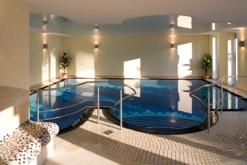 a large swimming pool in a building with a swimming pool at Landhotel Teuteberg in Bad Arolsen
