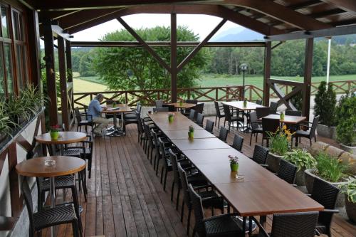 a patio with tables and chairs on a wooden deck at Hotel Oskar Zaplata in Preddvor