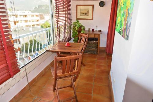 d'un balcon avec une table et des chaises en bois ainsi qu'une fenêtre. dans l'établissement Magnifique appartement Cassis, à Cassis