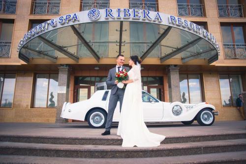 a bride and groom standing in front of a building at Ribera Resort&SPA in Yevpatoriya