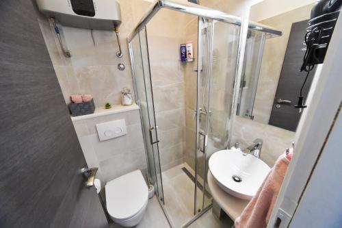 a bathroom with a shower and a toilet and a sink at Apartments and Rooms Nekic in Zadar