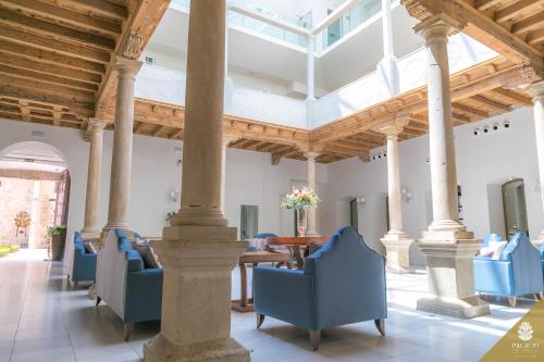 a large room with blue chairs and a table at Hotel Palacio De Úbeda 5 G.L in Úbeda