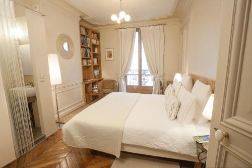 une chambre avec un lit blanc et une fenêtre dans l'établissement Le85 Paris, à Paris