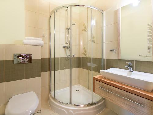 a bathroom with a shower and a toilet and a sink at VacationClub – Trzy Korony Wazów Apartament 9 in Świnoujście