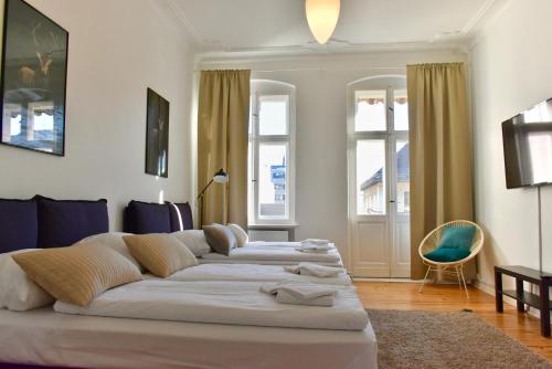 a living room with a large bed in a room with windows at Apartments im Thüringer Hof in Berlin