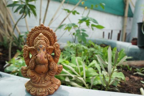 a small statue sitting on a table in a garden at Bed & Chai Guesthouse in New Delhi