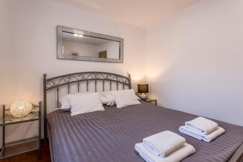 a bedroom with a bed with two towels on it at Apartments and Rooms Villa Erede in Split
