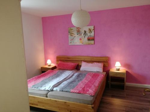 um quarto com uma cama com uma parede roxa em Ferienwohnung ELSA em Immenstadt im Allgäu