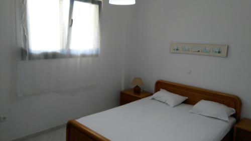 a white bedroom with a bed and a window at Garden maisonnette 2-bedrooms sleeps 6 adults 200m from sandy beach in Asprovalta