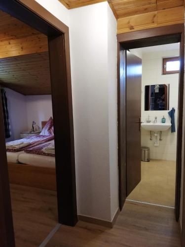 a door leading to a bedroom with a bed and a sink at Ferienwohnung Holiday Lienz in Lienz