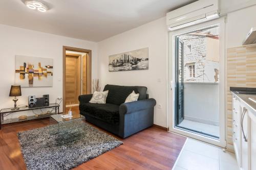 a living room with a couch and a window at Apartments and Rooms Villa Erede in Split
