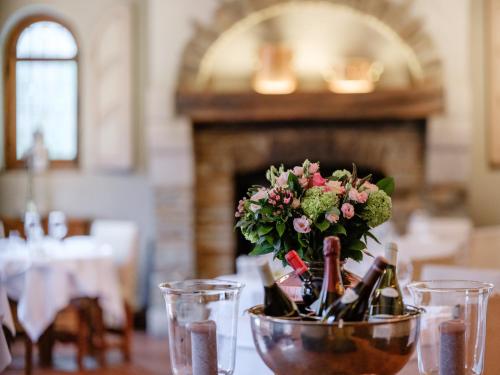 a vase filled with wine bottles and flowers on a table at Hotel Auberge D'Alle in Alle