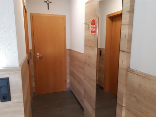 a hallway with a wooden door in a building at Hotel Bigger Hof - Wirtshaus Platzhirsch am Jahnplatz in Olsberg