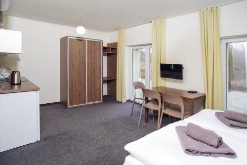 a hotel room with a desk and a table at Penzion Lesni in Milovice