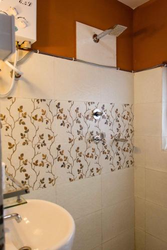 a bathroom with a sink and a wall with a flower pattern at Wander Thirst in Kathmandu