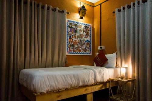 a bedroom with a bed with curtains and a painting at Wander Thirst in Kathmandu