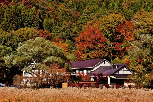a house in the middle of a field with trees at Akasawa Onsen Ryokan in Nasushiobara