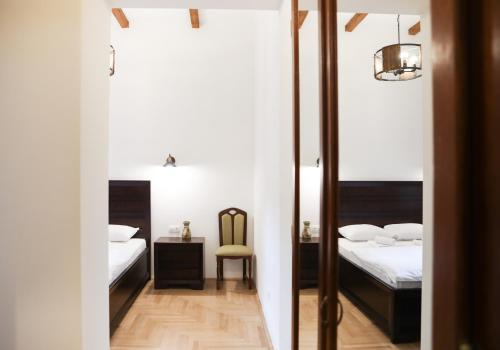 een slaapkamer met 2 bedden en een bureau met een stoel bij Contessa Central Studio in Cluj-Napoca