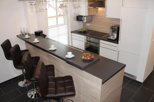 a kitchen with a counter and chairs in a kitchen at 5*Ferienwohnung Seebrise 1 in Wendisch Rietz