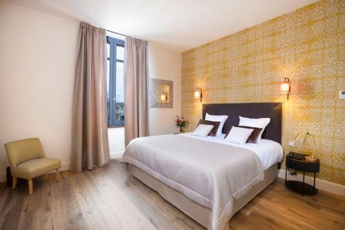 a bedroom with a large white bed and a window at Hotel Clos Castel Villas Spa in Casteljaloux