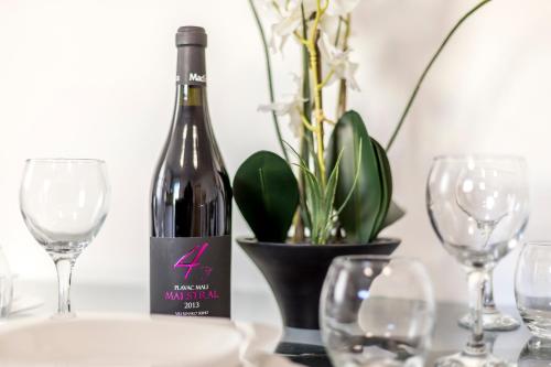 a bottle of wine sitting on a table with glasses at Apartments and Rooms Villa Erede in Split
