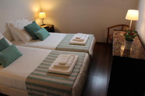 a hotel room with two beds with towels on them at Pátio Mateus in Areia Branca