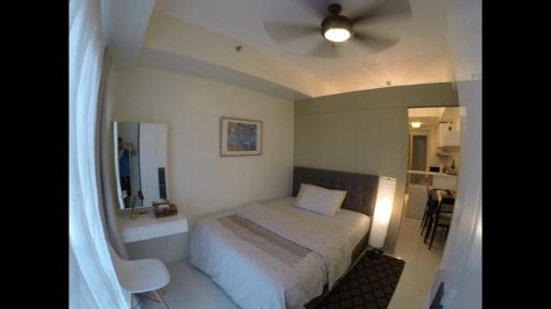 a small bedroom with a bed and a ceiling fan at Wind Residences cool breeze & amazing tagaytay view in Tagaytay