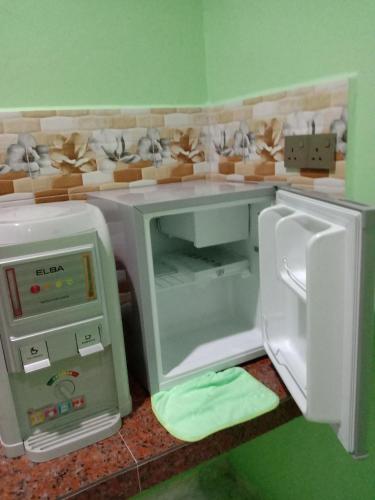 a toy kitchen with an open refrigerator and a microwave at DYANA INN TRANSIT ROOMS in Kota Bharu