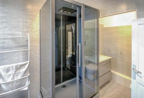 uma cabina de duche em vidro numa casa de banho com WC em Maison de Mallast em Montolieu