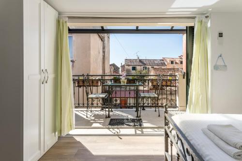 a bedroom with a bed and a balcony with a table at Apartments and Rooms Villa Erede in Split