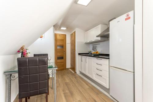 a kitchen with white cabinets and a refrigerator at Apartments and Rooms Villa Erede in Split