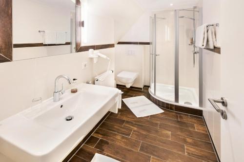 a bathroom with a sink and a shower and a toilet at Landgasthaus Kathmann- bed and breakfast in Dinklage