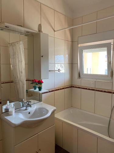 a bathroom with a sink and a tub and a window at Pansion Villa Bubalo in Mostar