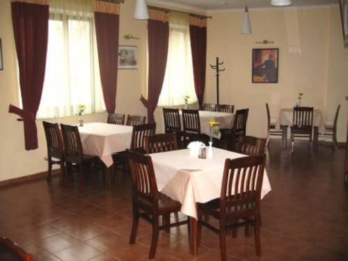 une salle à manger avec tables et chaises et nappes blanches dans l'établissement Готель Леон, à Zwiahl