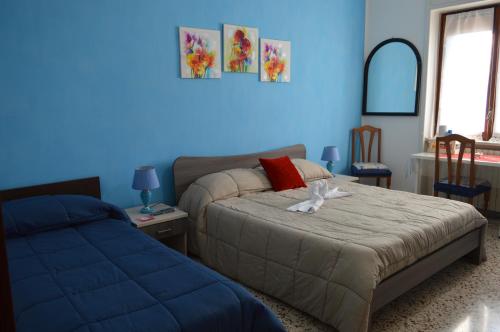 une chambre avec un lit et un mur bleu dans l'établissement B&B Olympo, à Salerne