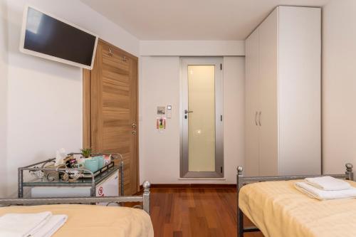 a bedroom with two beds and a tv on the wall at Apartments and Rooms Villa Erede in Split
