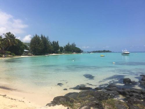 a view of a beach with a boat in the water at Element Bay Lux Beach Apartment in Cap Malheureux