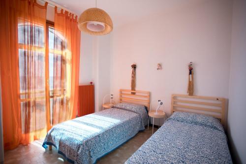 two beds in a room with a window at Villa Layla on the beach in Torre Lapillo