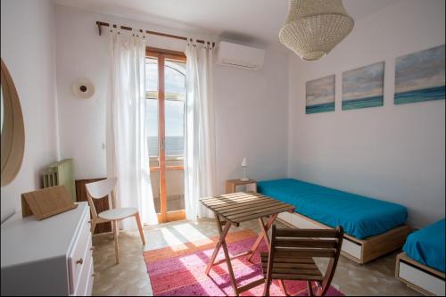 a bedroom with a bed and a table and chairs at Villa Layla on the beach in Torre Lapillo