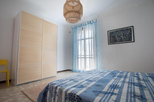 a bedroom with a bed and a large window at Villa Layla on the beach in Torre Lapillo