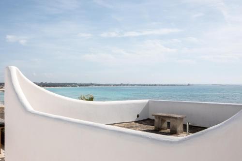 a small white boat with a table in it at Villa Layla on the beach in Torre Lapillo